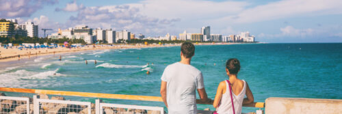 Miami beach people lifestyle young tourists couple walking in South Beach, Miami, Florida. USA travel. Panoramic banner background.