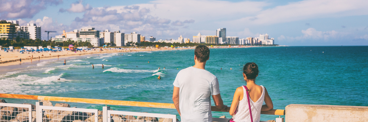 Miami beach people lifestyle young tourists couple walking in South Beach, Miami, Florida. USA travel. Panoramic banner background.